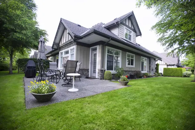 Well kept green lawn and planted beds beside a Surrey home